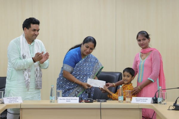 दिल्ली सचिवालय में शुक्रवार को दिल्ली हाट आग्निकांड से प्रभावित शिल्पकारों को पांच-पांच लाख रुपये कै चैक देती मु