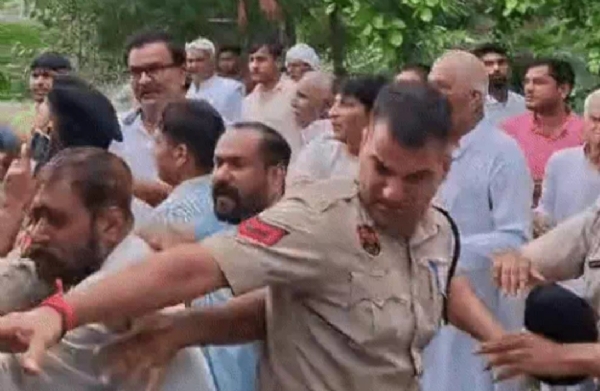 बापौली के आर्य समाज मंदिर में लोगों पर हमला कर रहे लोगों को समझाती पुलिस
