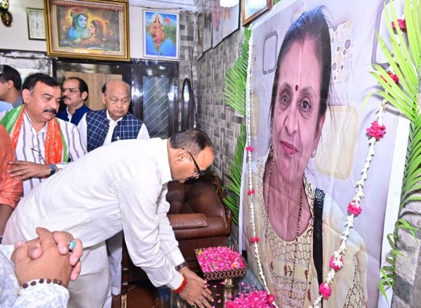 संदीप बंसल की माता के चित्र पर पुष्पांजलि अर्पित करते राजनाथ सिंह