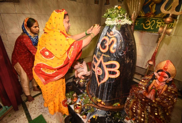 श्रावण के पहले सोमवारी को शिव मंदिर में भगवान शिव का अभिषेक करते श्रद्धालु