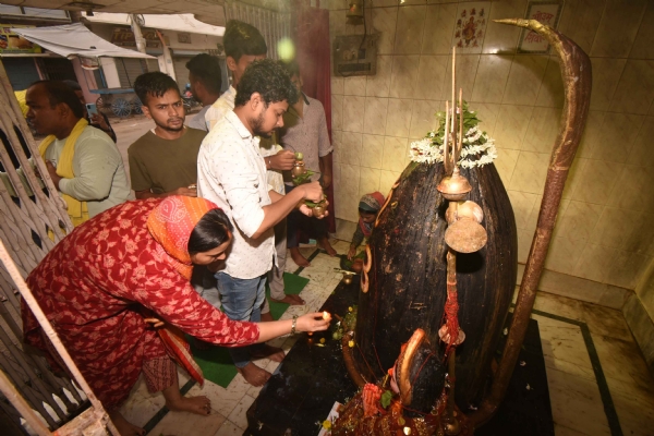 श्रावण के पहले सोमवारी को शिव मंदिर में भगवान शिव का अभिषेक करते श्रद्धालु