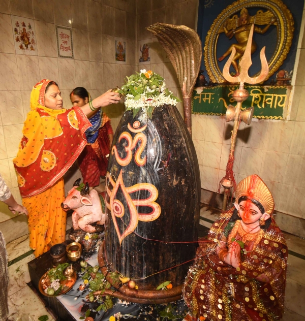श्रावण के पहले सोमवारी को शिव मंदिर में भगवान शिव का अभिषेक करते श्रद्धालु
