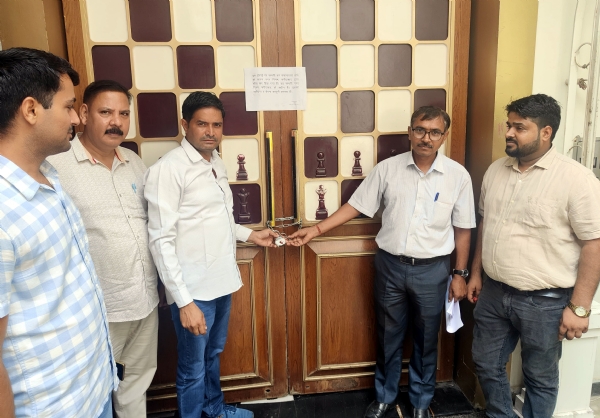 सील करते निगम के अधिकारी