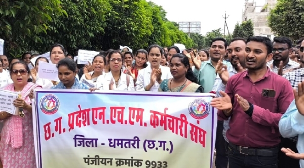 बेरिकेड के सामने विरोध प्रदर्शन करते हुए एनएचएम कर्मचारी।