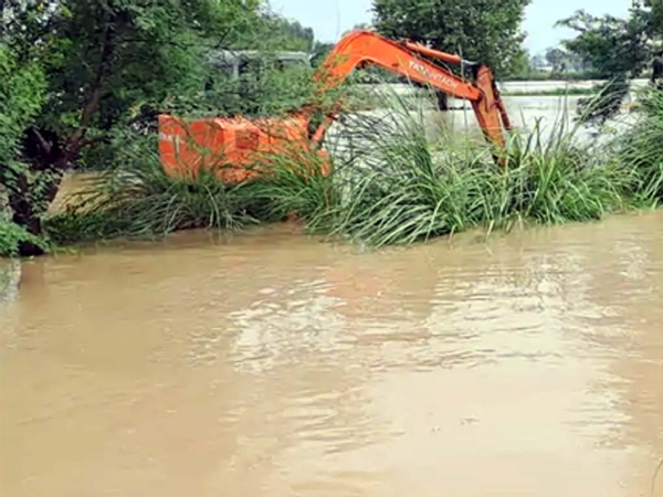 जेसीबी की सहायता से दरार पाटने का प्रयास करते कर्मचारी।