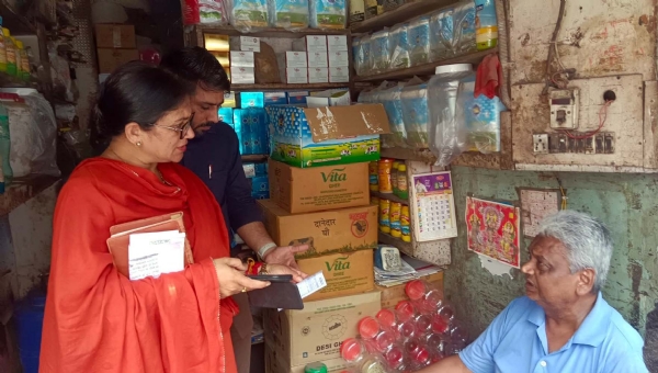 दुकानदार से पूछताछ करके सीएम फ्लाइंग टीम के अधिकारी।
