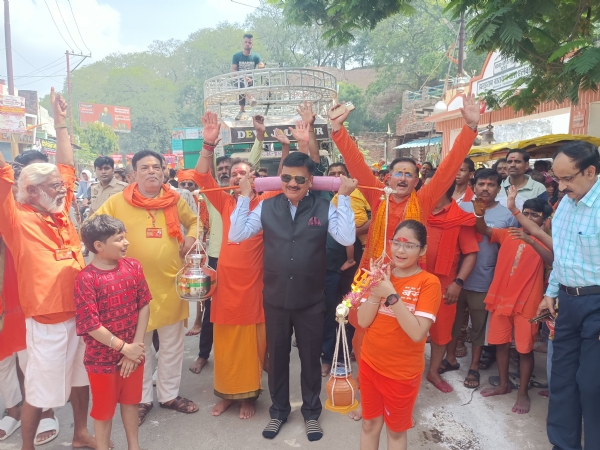 जिलाधिकारी कांवड़ उठाते हुए