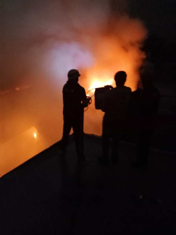 आग बुझाते सुरक्षा कर्मी।