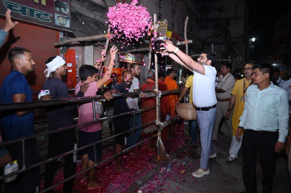बाबा विश्वनाथ के दरबार में श्रद्धालुओं पर पुष्पवर्षा करते अफसर