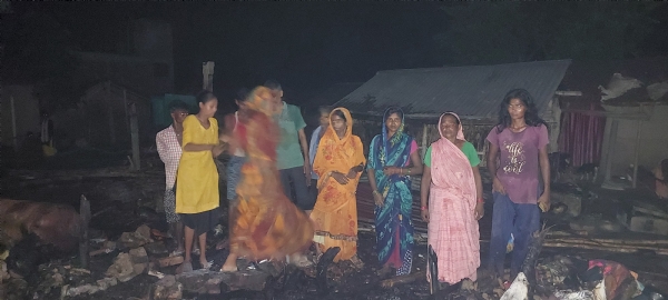 घर के जले हुए राख पर परिवार की महिलाएं
