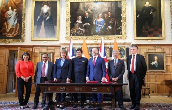 एफटीए पर हस्‍ताक्षर करते पीयूष गोयल और उनके ब्रिटिश समकक्ष जोनाथन रेनॉल्ड्स