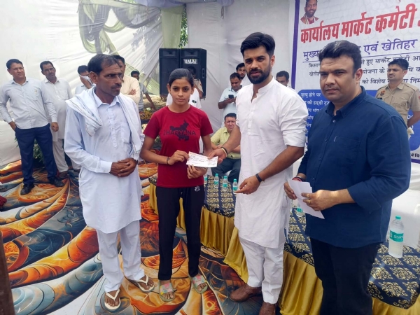 सहायता राशि के चैक वितरित करते हुए भव्य बिश्नोई।