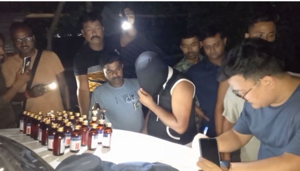 प्रतिबंधित कफ सिरप के साथ गिरफ्तार युवक से पूछताछ करती पुलिस