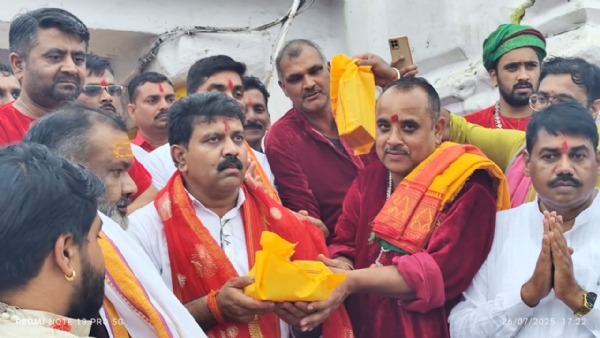 नर्मदा मंदिर में पुजारी उपमुख्यमंत्री काे प्रसाद देते