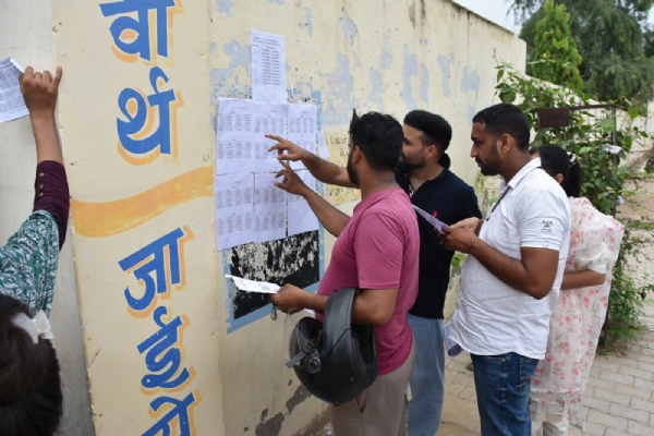 फतेहाबाद। परीक्षा केंद्रों के बाहर अपना रोल नंबर चेक करते परीक्षार्थी।