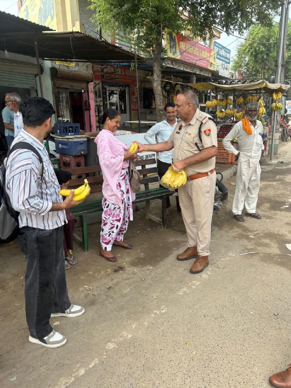 फतेहाबाद। परीक्षार्थियों को फल वितरित करते पुलिस कर्मचारी।