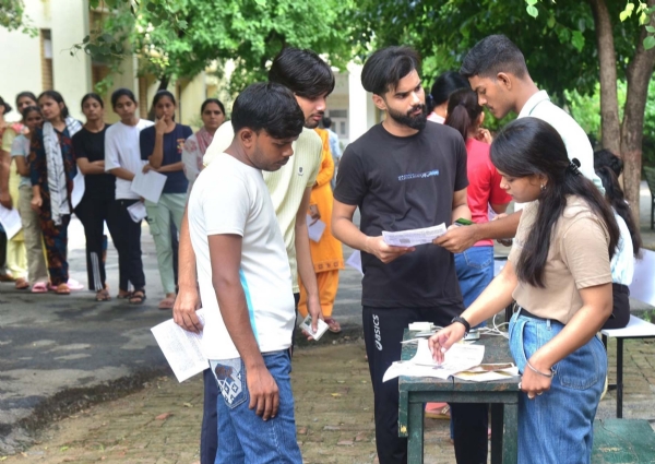 गुरुग्राम में सीईटी परीक्षा देने पहुंचे परीक्षार्थियों के प्रवेश पत्र जांचते ड्यूटीकर्मी।