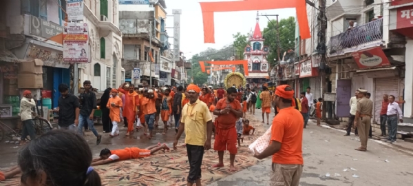 दंडवत लेटकर जलाभिषेक के लिए जाते हुए भक्त