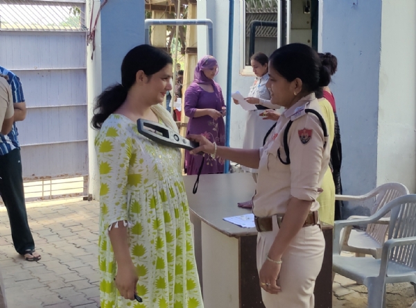 बाल विकास स्कूल में बने परीक्षा केंद्र में प्रवेश से पहले परीक्षार्थियों की जांच करती महिला पुलिसकर्मी।