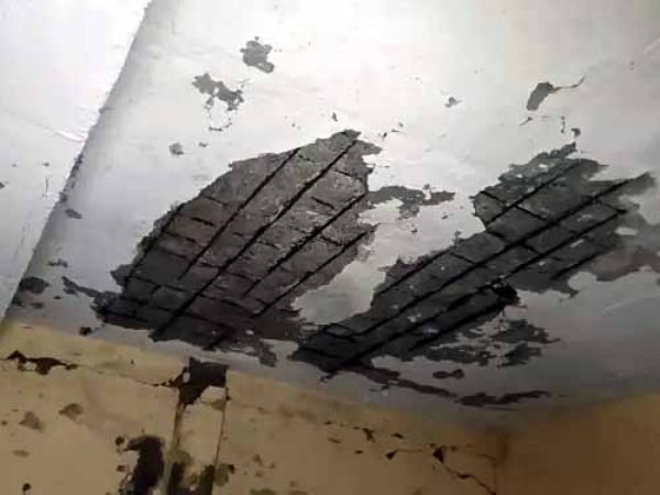 छत से झड़ रहा प्लास्तर व बेंचों पर पड़ा मलबा।
