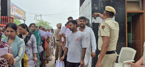 परीक्षा केंद्र में प्रवेश से पहले दस्तावेजों की जांच करती पुलिस।