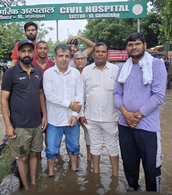 गुरुग्राम के सेक्टर-10 नागरिक अस्पताल के सामने भरे पानी में लाेगाें के साथ खड़े कांग्रेस नेता पंकज डावर।