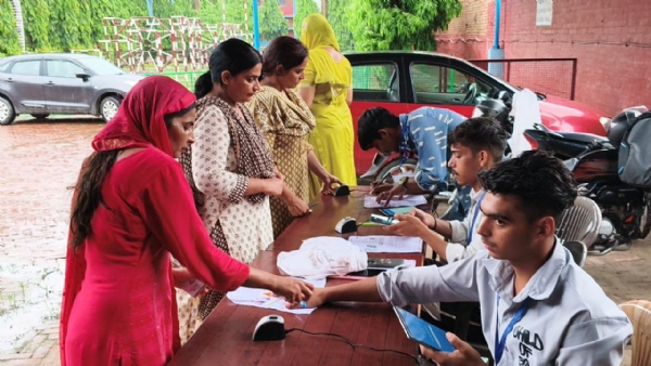 बायोमेट्रिक करते हुए कर्मी।