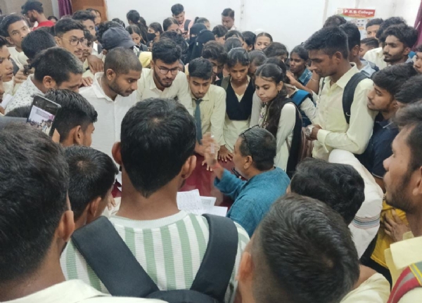 परीक्षा नियंत्रक से बात करते छात्र