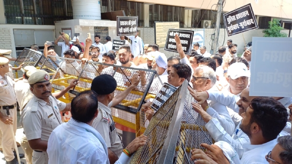 कांग्रेस कार्यकर्ताओं को बेरिकेट्स लगाकर रोकती पुलिस।