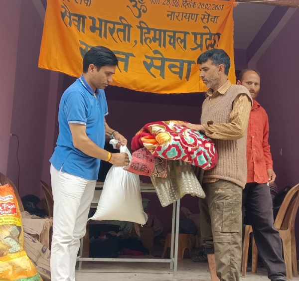 आपदा प्रभावितों को राहत सामग्री देते हुए सेवा भारती कार्यकर्ता।