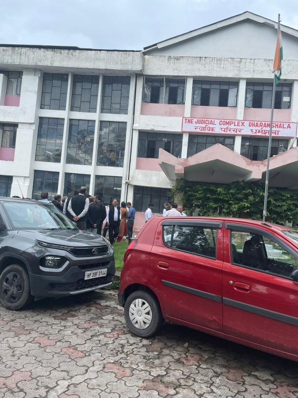 बम की धमकी के बाद परिसर में खड़े वकील और अन्य।