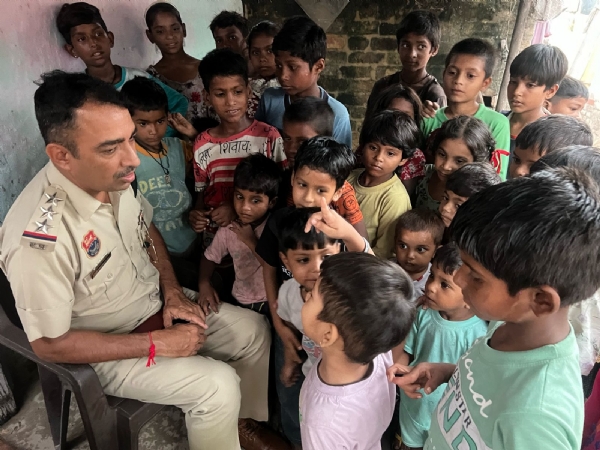 पंचकूला के पुलिस अधिकारी झाैंपड़ पट्टी क्षेत्र के बच्चाें से मिलते हुए