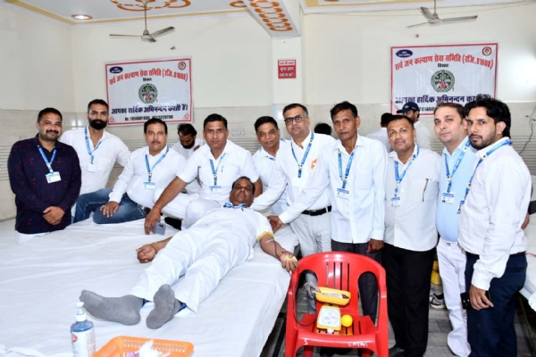 शिविर में रक्तदान करते समिति पदाधिकारी।