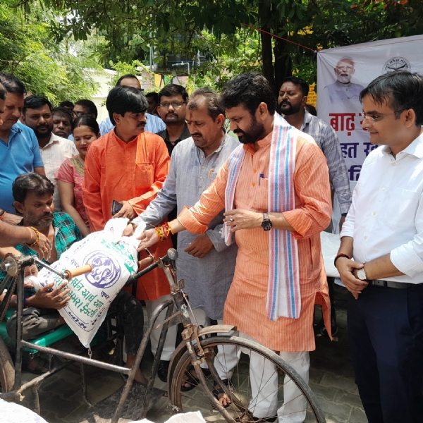 प्रभावित क्षेत्र में आयुष मंत्री और जिलाधिकारी दिव्यांग को राहत सामग्री देते हुए