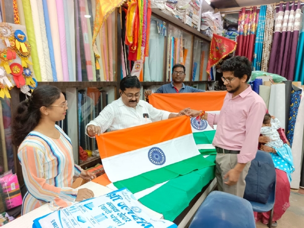 शहर की एक दुकान में तिरंगा झंडा खरीदते हुए लोग।