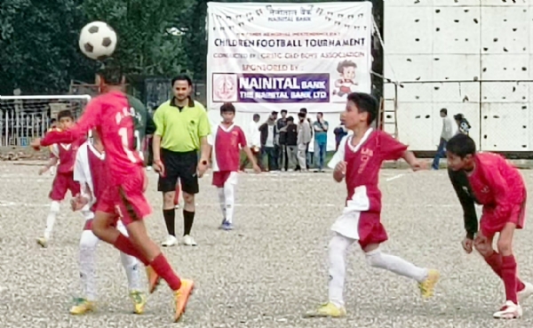 फुटबॉल प्रतियोगिता में गैंद के लिये भिड़ते खिलाड़ी।