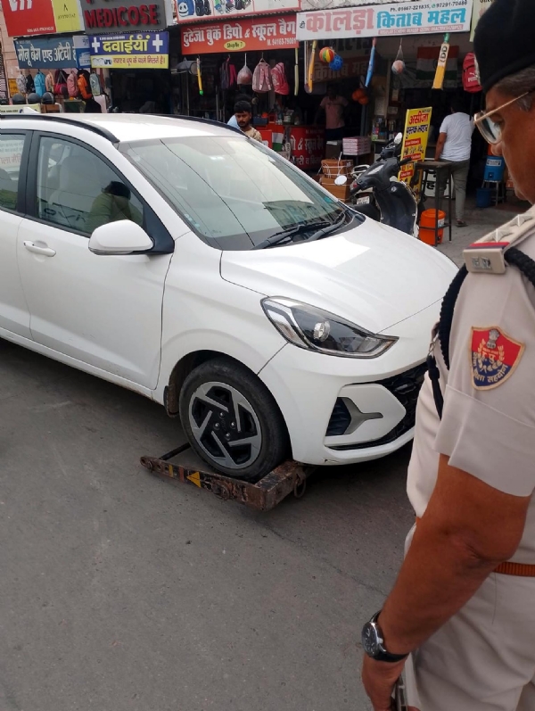 फतेहाबाद। गाड़ी को टोचन कर ले जाते ट्रेफिक पुलिस कर्मचारी।
