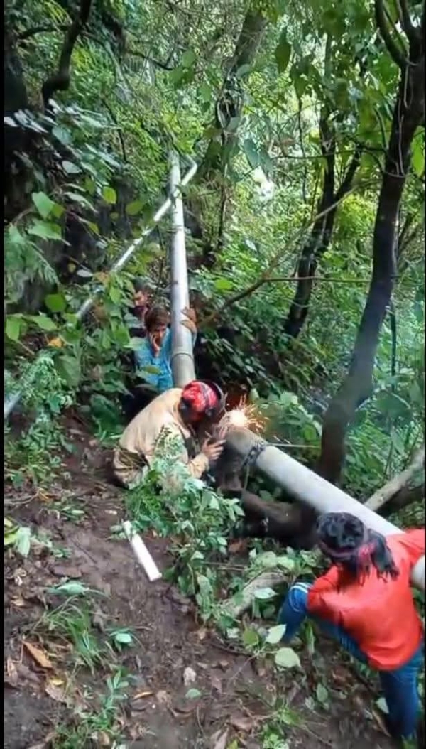 टूटी पाईप लाइन की मुरम्मत करते हुए विभागीय कर्मी।
