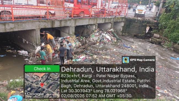 बारिश के बाद नालाें में फंसे कचरे काे साफ करते निगम कर्मी।