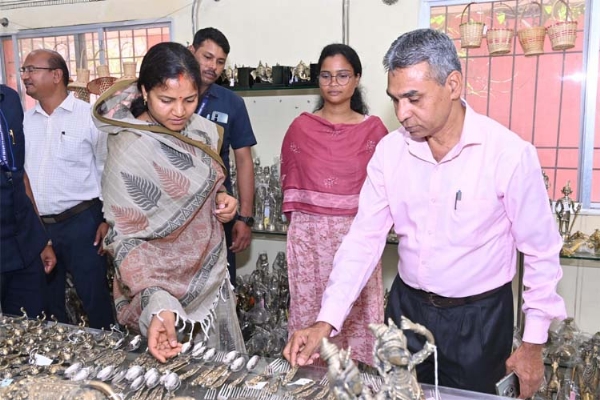 मंत्री लक्ष्मी राजवाड़े शबरी एंपोरियम में बेलमेटल कला की कलाकृतियों का अवलोकन करते हुए