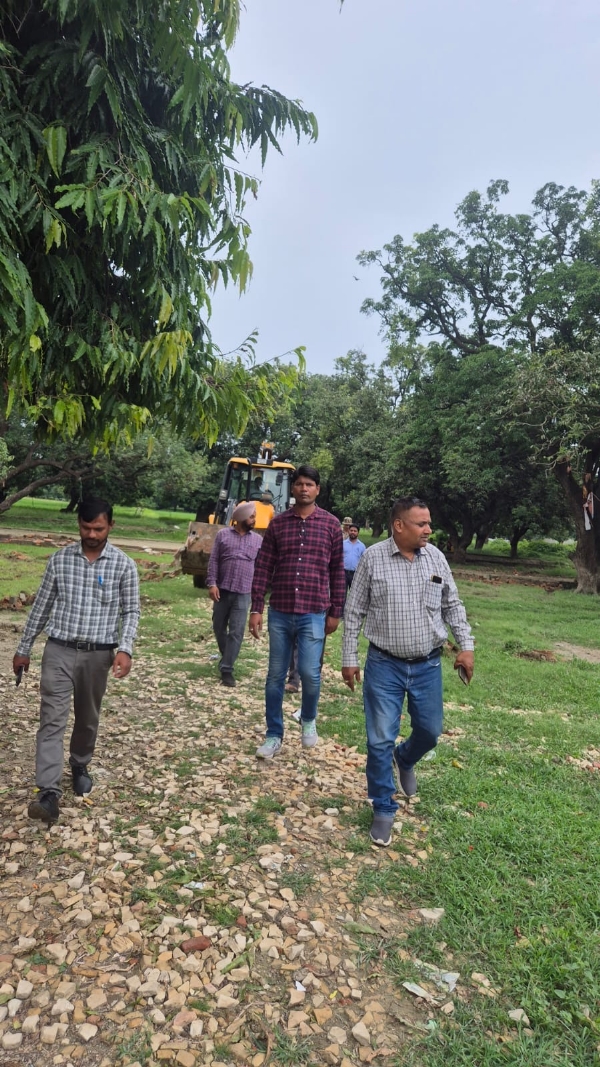 जमीन की निशानदेही मिटाते बीडीए की प्रवर्तन टीम के कर्मचारी।