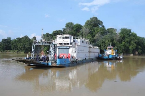 असम में जलमार्ग से सीमेंट को ले जाता जहाज
