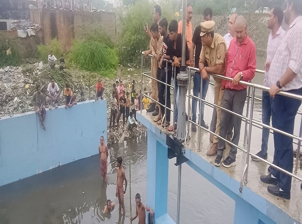 नाले में बहे  बच्चे को खोजते गोताखोर