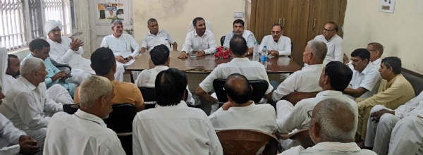 जिला अध्यक्ष बृजलाल से बातचीत करते रिटायर्ड कर्मचारी।