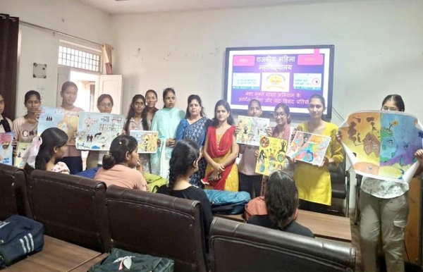 पोस्टर मेकिंग प्रतियोगिता के साथ छात्राएं साथ में स्टाफ सदस्य।