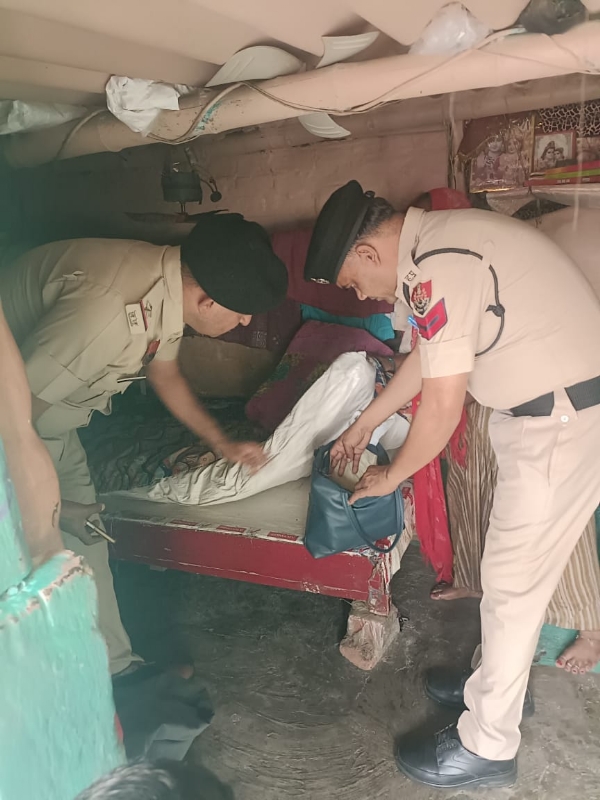 एक संदिग्ध व्यक्ति के घर में तलाशी लेते पुलिसकर्मी।