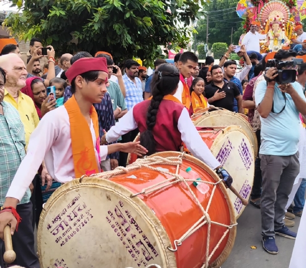गणेश चतुर्थी के पावन पर गजानन की प्रतिमा की स्थापना से पूर्व शोभायात्रा में  ढोल नगाड़े बजाते लोग।