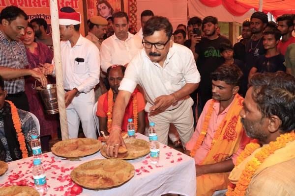 शिवभक्तों को प्रसाद परोसते डीएम