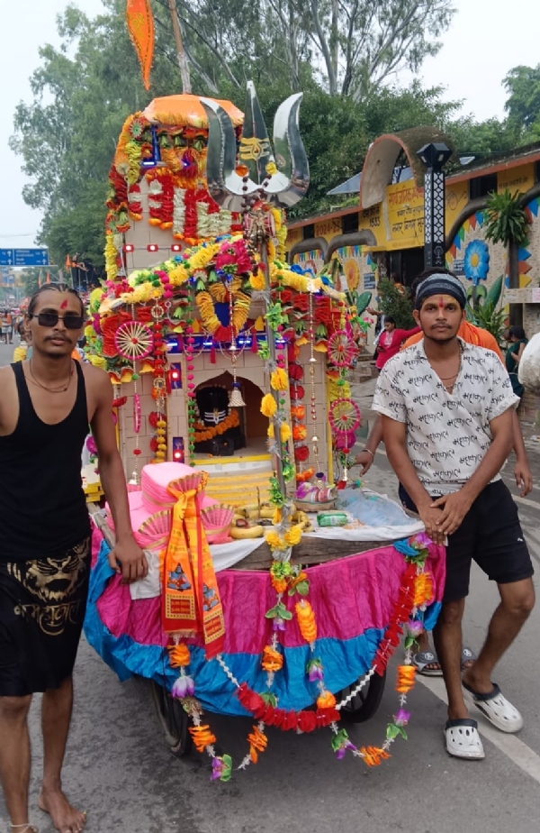 बृजघाट से ठेले पर कावड़ में गंगाजल लेकर आते भक्त।