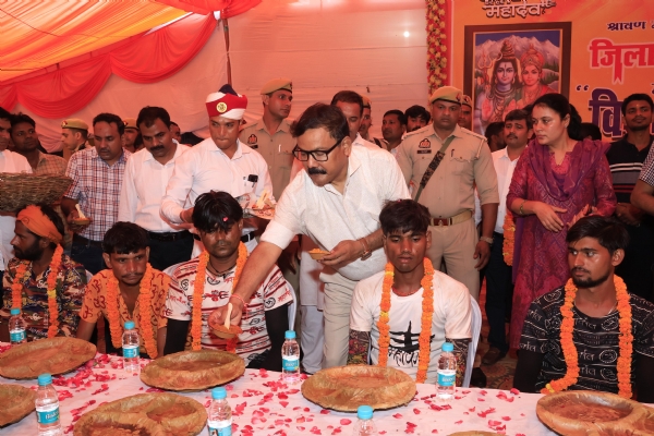शिवभक्तों को प्रसाद परोसते डीएम